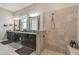 Bathroom featuring tiled shower with glass surround, dual sinks, granite counters and makeup vanity at 31840 Magna Gulf Loop, San Antonio, FL 33576