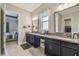 Bathroom featuring dual sinks, granite counters, makeup vanity and access to bedroom and closet at 31840 Magna Gulf Loop, San Antonio, FL 33576