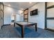 Well-appointed billiard room with exposed brick, TV and modern lighting fixture at 31840 Magna Gulf Loop, San Antonio, FL 33576
