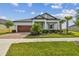 Beautiful home showcasing a well-manicured lawn, mature trees, and colorful flower beds enhancing the curb appeal at 31840 Magna Gulf Loop, San Antonio, FL 33576