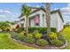 Charming home with beautiful landscaping, including palm trees and vibrant plants, and a welcoming entryway at 31840 Magna Gulf Loop, San Antonio, FL 33576