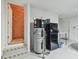 Garage interior featuring water heater, refrigerator, storage, and steps to separate unfinished storage space at 31840 Magna Gulf Loop, San Antonio, FL 33576