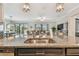 Modern kitchen featuring a large island with sink, granite counters, stainless steel appliances, and open floor plan at 31840 Magna Gulf Loop, San Antonio, FL 33576