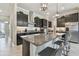 Well-lit kitchen boasts a large island, granite countertops, modern stainless steel appliances, and dark cabinetry at 31840 Magna Gulf Loop, San Antonio, FL 33576