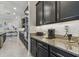 Stylish kitchen with granite countertops, stainless steel appliances, and dark cabinetry, with convenient countertop appliances at 31840 Magna Gulf Loop, San Antonio, FL 33576