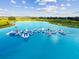 Aerial view of the inflatable water park in a community's resort style lagoon at 31840 Magna Gulf Loop, San Antonio, FL 33576