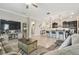 Comfortable living room featuring a large TV, display cabinet, and seamless transition to the kitchen at 31840 Magna Gulf Loop, San Antonio, FL 33576