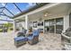 Wide shot of a screened patio with seating, dining, an outdoor kitchen, and lake views at 31840 Magna Gulf Loop, San Antonio, FL 33576