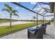 Outdoor lounge seating on the screened patio overlooking the lawn and the lake at 31840 Magna Gulf Loop, San Antonio, FL 33576