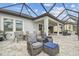 Large screened patio with multiple seating areas including a dining area and lounge furniture at 31840 Magna Gulf Loop, San Antonio, FL 33576