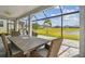 Covered and screened patio with outdoor dining, view of the lawn, and lake at 31840 Magna Gulf Loop, San Antonio, FL 33576