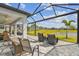 Spacious screened patio with lounge and dining areas, ceiling fan, and views of the lawn and lake at 31840 Magna Gulf Loop, San Antonio, FL 33576