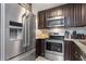 Kitchen with stainless steel appliances, brown cabinets, and granite countertops at 3221 White Ibis Ct # C1, Punta Gorda, FL 33950