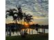 Sunset view over the community waterway with dock and palm trees at 3221 White Ibis Ct # C1, Punta Gorda, FL 33950