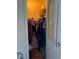 Walk-in closet with an ironing board, hanging clothes, storage boxes, and shoes at 3585 41St S Way # D, St Petersburg, FL 33711