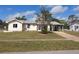 Charming single-story home with a well-manicured lawn, front tree, and a convenient carport at 4299 Bullard St, North Port, FL 34287