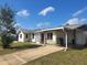 View of the home’s front exterior, boasting a functional carport and a well-maintained lawn at 4299 Bullard St, North Port, FL 34287
