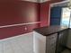 Kitchen view featuring white cabinets, tile flooring, and red accent wall at 4299 Bullard St, North Port, FL 34287