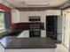 Open kitchen featuring granite countertops, white cabinets, and stainless steel appliances at 4299 Bullard St, North Port, FL 34287