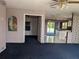 View of the living room leading to the kitchen, with an open floor plan and neutral carpet at 4299 Bullard St, North Port, FL 34287
