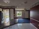 View of the living room with dark blue carpet, floral wallpaper, and view to the front yard at 4299 Bullard St, North Port, FL 34287