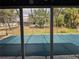 Pool view from lanai with a screen enclosure surrounded by lush green landscaping in the backyard at 4299 Bullard St, North Port, FL 34287