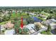 Beautiful aerial view of the property showcasing a serene pond and lush, mature landscaping at 12519 Knollbrook Ln, Hudson, FL 34669