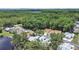 Aerial view showing the home's location surrounded by lush green trees and landscaping at 12519 Knollbrook Ln, Hudson, FL 34669