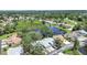 Beautiful aerial view of the property showcasing a serene pond and lush, mature landscaping at 12519 Knollbrook Ln, Hudson, FL 34669