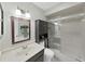 This bathroom features a shower, bathtub, dark cabinetry, lighting, and a mirror at 12519 Knollbrook Ln, Hudson, FL 34669