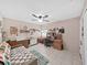 This bedroom features tile floors, a ceiling fan, and a sewing/crafting area at 12519 Knollbrook Ln, Hudson, FL 34669