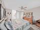 This bedroom features a ceiling fan, wood-look floors, a dresser, and bed with comforter at 12519 Knollbrook Ln, Hudson, FL 34669