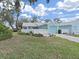 Charming home features a well-manicured lawn, complemented by a cute white fence, beautiful plants and an attached garage at 12519 Knollbrook Ln, Hudson, FL 34669