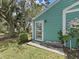 Exterior side view of a blue-green home with white trim and lush greenery at 12519 Knollbrook Ln, Hudson, FL 34669