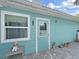 Aqua home exterior showing the door, window, brick floor, and blue siding at 12519 Knollbrook Ln, Hudson, FL 34669