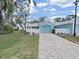 Cozy home featuring a well-maintained front yard and a paver driveway leading to an attached garage with an adorable picket fence at 12519 Knollbrook Ln, Hudson, FL 34669