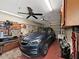 A well-organized garage with a vehicle, fan, and tool storage at 12519 Knollbrook Ln, Hudson, FL 34669