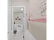 This hallway has wainscoting and a bathroom with view of cabinets and sink at 12519 Knollbrook Ln, Hudson, FL 34669