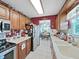 Functional kitchen offers white countertops, wood cabinets, and an adjacent dining area at 12519 Knollbrook Ln, Hudson, FL 34669