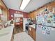 Efficient kitchen with essential appliances, white tile floor, and wooden cabinetry at 12519 Knollbrook Ln, Hudson, FL 34669