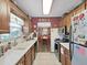 Traditional kitchen features white countertops, appliances, and direct access to the dining room at 12519 Knollbrook Ln, Hudson, FL 34669