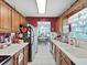 Functional kitchen features tile flooring, oak cabinets, and a view into the dining area at 12519 Knollbrook Ln, Hudson, FL 34669