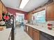 Functional kitchen features tile flooring, oak cabinets, and a view into the dining area at 12519 Knollbrook Ln, Hudson, FL 34669