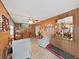 Cozy living room with wood-paneled walls, tile flooring, and a ceiling fan at 12519 Knollbrook Ln, Hudson, FL 34669