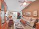 Inviting living room with wood flooring, a ceiling fan, and lots of natural light at 12519 Knollbrook Ln, Hudson, FL 34669