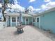 Brick paved patio provides an inviting outdoor retreat with an umbrella table, chairs, and a tranquil view of the clear blue sky at 12519 Knollbrook Ln, Hudson, FL 34669