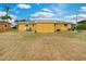 Expansive backyard with lush green grass, patio seating, and a bright yellow exterior at 2616 Bayshore Gardens Pkwy, Bradenton, FL 34207