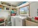 Laundry room with washer, dryer, storage shelves, and a window at 2616 Bayshore Gardens Pkwy, Bradenton, FL 34207