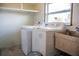 Functional laundry room with washer, dryer, utility sink, and storage shelving, providing convenience and organization at 2616 Bayshore Gardens Pkwy, Bradenton, FL 34207