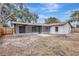 Wide view of the backyard with a patio area, trees, and exterior of the house at 623 Sandy Creek Dr, Brandon, FL 33511